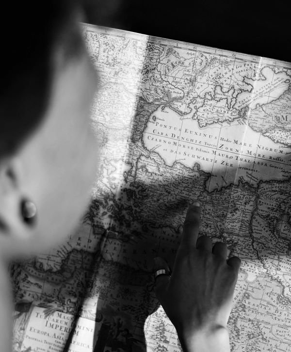Pessoa apontando para um mapa durante o planejamento de uma viagem, representando a definição de metas e o planejamento financeiro.