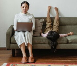 mãe solo organizando planejamento financeiro no laptop em casa