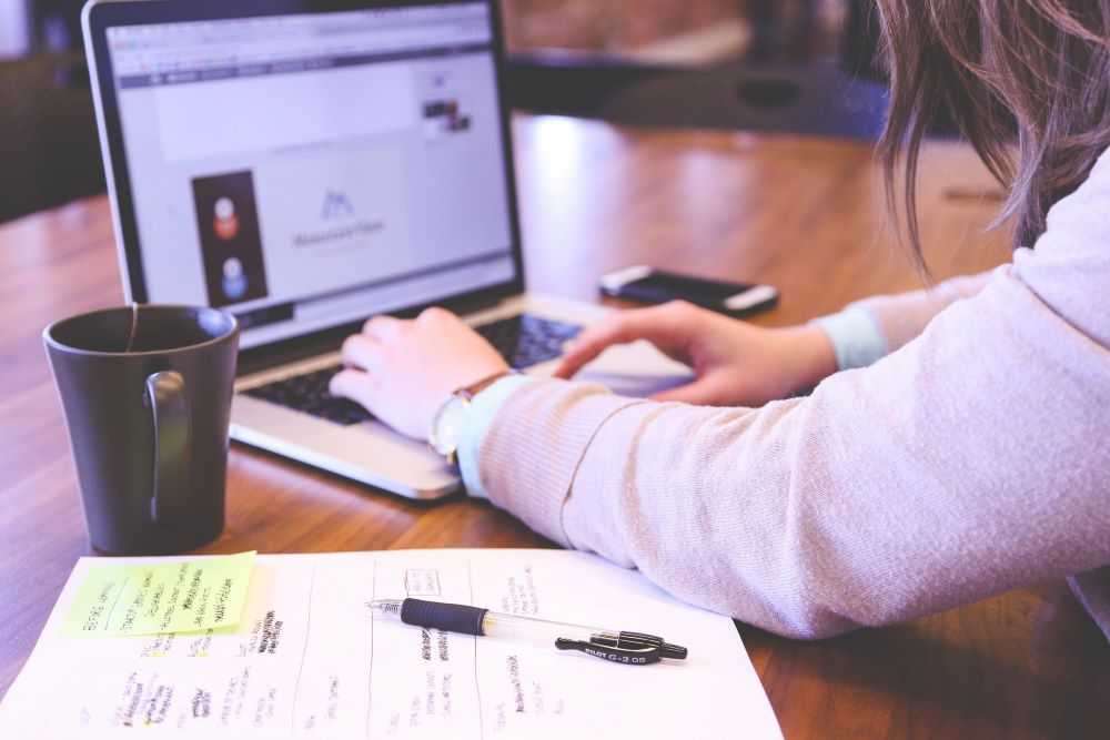 “Mulher usando notebook para organizar planejamento financeiro e contas do dia a dia”