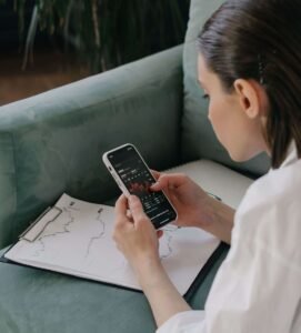 Mulher analisando investimentos pelo celular