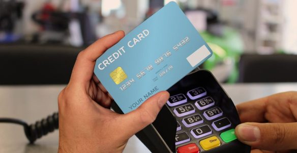 pessoa pagando com cartão de crédito e controlando finanças