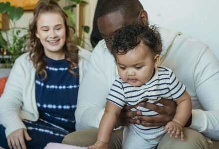Casal brincando com o bebe em casa planejando seu primeiro ano de vida