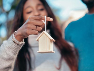 Economizando dinheiro para comprar casa com moedas e chave de imóvel